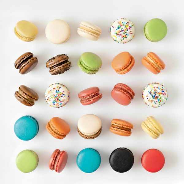 Rows of strawberry and vanilla macarons, 24 count, arranged neatly on a white background.